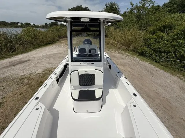 Slide: The Image of 2024 Tidewater 2410 Bay Max boat on a dirt path near lush greenery. - 20
