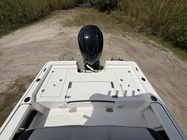 Slide: The Image of 2024 Tidewater 2410 Bay Max boat with outboard motor on a sandy path. - 23