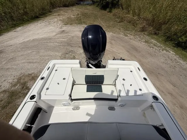 Slide: The Image of 2024 Tidewater 2410 Bay Max boat, rear view with motor, on a sandy path. - 24