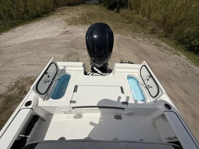 Slide: The Image of 2024 Tidewater 2410 Bay Max boat with open storage compartments and outboard motor. - 25