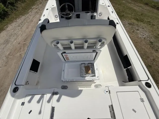 Slide: The Image of 2024 Tidewater 2410 Bay Max boat interior with open storage compartment and rod holders. - 29