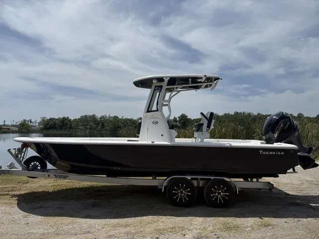 Slide: The Image of 2024 Tidewater 2410 Bay Max boat on trailer, parked outdoors under cloudy sky. - 8