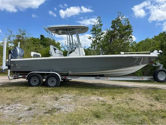 Slide: The Image of 2021 Pathfinder 2600 HPS boat on trailer, parked outdoors under a blue sky. - 1