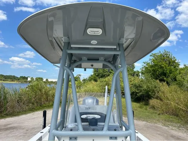Slide: The Image of 2021 Pathfinder 2600 HPS boat with T-top, parked near a scenic lake. - 10