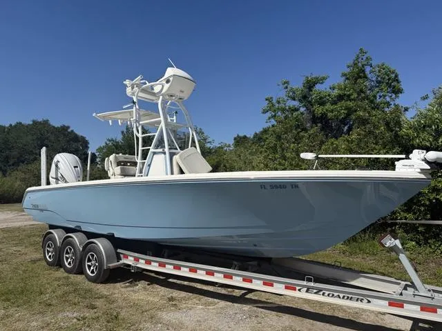 Slide: The Image of 2023 Pathfinder 2700 Open boat on trailer, light blue hull, parked outdoors. - 1