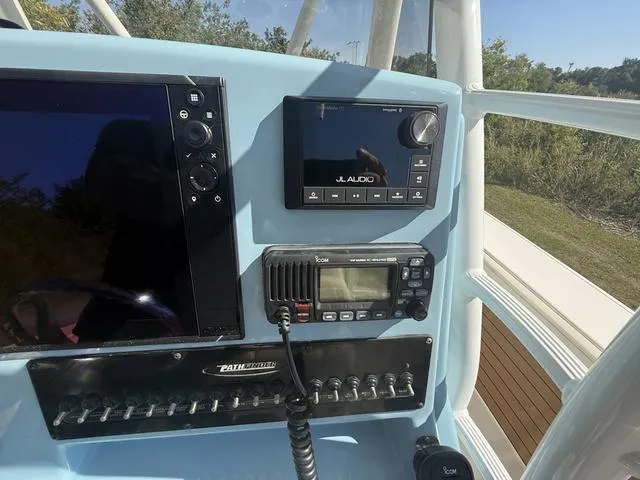 Slide: The Image of Control panel of 2023 Pathfinder 2700 Open boat with electronic displays and radio. - 13