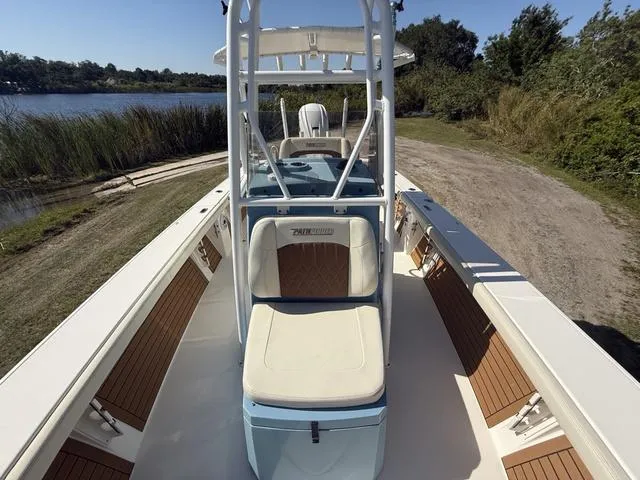 Slide: The Image of 2023 Pathfinder 2700 Open boat with seating, docked by a scenic lakeside. - 22