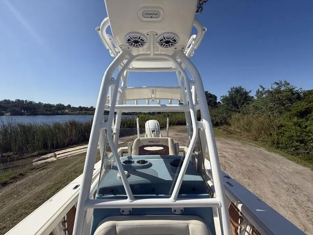 Slide: The Image of 2023 Pathfinder 2700 Open boat with T-top, parked near a scenic lake. - 23