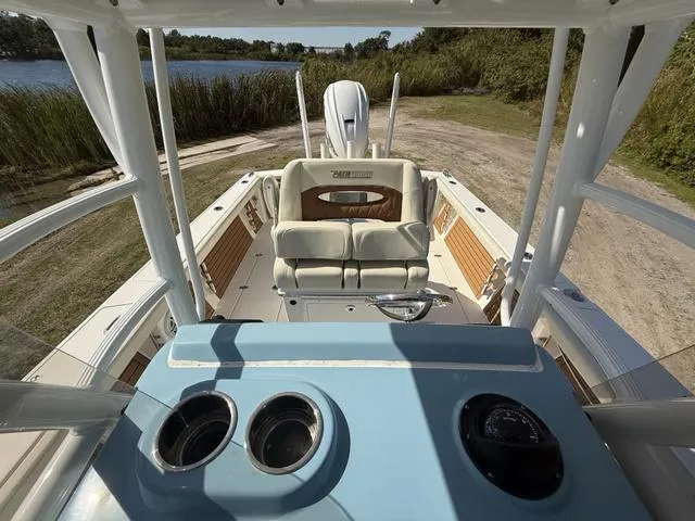 Slide: The Image of 2023 Pathfinder 2700 Open boat interior with seating and console, near a lake. - 24