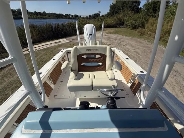 Slide: The Image of 2023 Pathfinder 2700 Open boat interior with seating and steering, near a scenic waterway. - 25