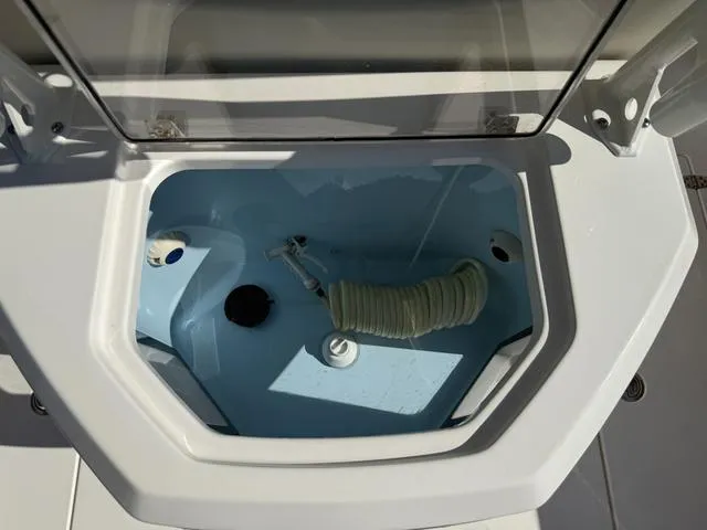 Slide: The Image of Livewell compartment on a 2023 Pathfinder 2700 Open boat, featuring a hose and drainage system. - 33