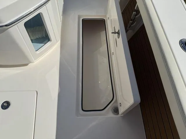 Slide: The Image of 2023 Pathfinder 2700 Open boat storage compartment with open lid, showcasing interior space. - 37