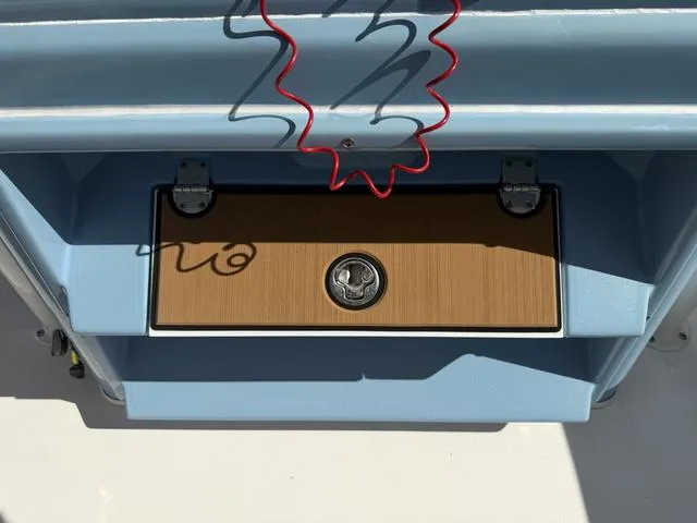 Slide: The Image of 2023 Pathfinder 2700 Open boat storage compartment with latch and red cord. - 40