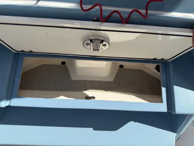 Slide: The Image of 2023 Pathfinder 2700 Open boat compartment with latch and red cord. - 41