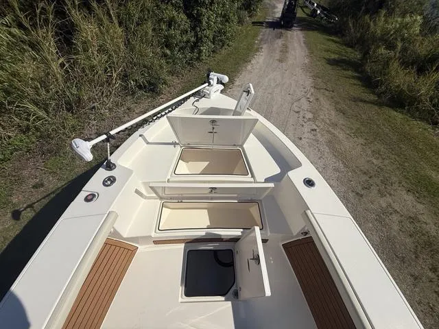 Slide: The Image of 2023 Pathfinder 2700 Open boat with open storage compartments on a dirt path. - 49