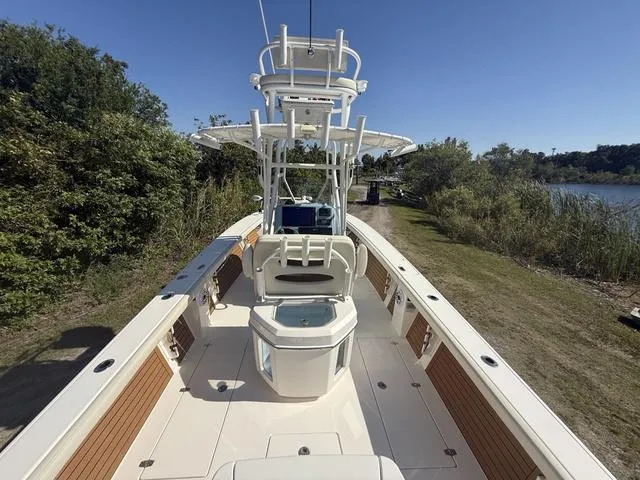 Slide: The Image of 2023 Pathfinder 2700 Open boat with center console and tower, docked near lush greenery. - 9
