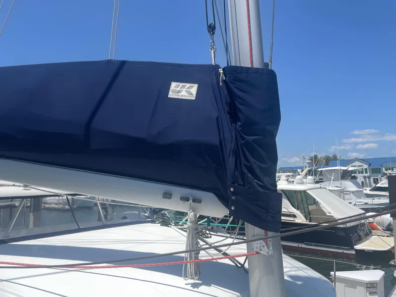 Slide: The Image of 2016 Lagoon 380 sailboat with blue sail cover, docked at marina under clear sky. - 12