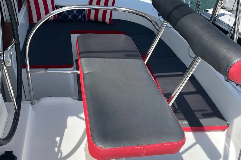 Slide: The Image of Cockpit seating on 2016 Lagoon 380 catamaran with red and gray cushions. - 14