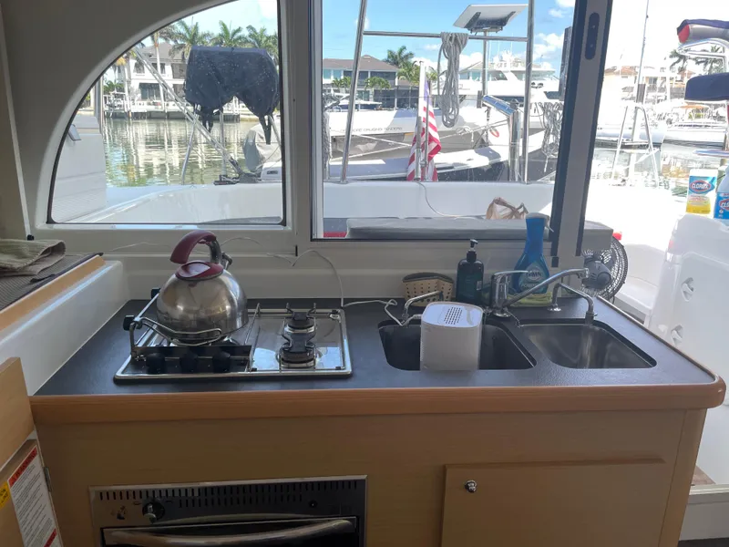 Slide: The Image of Interior view of a 2016 Lagoon 380 catamaran kitchen with stove and sink. - 22