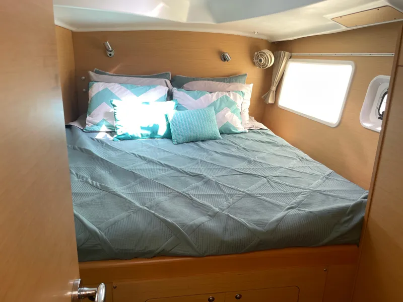 Slide: The Image of Cozy bedroom in 2016 Lagoon 380 catamaran with teal bedding and natural light. - 25