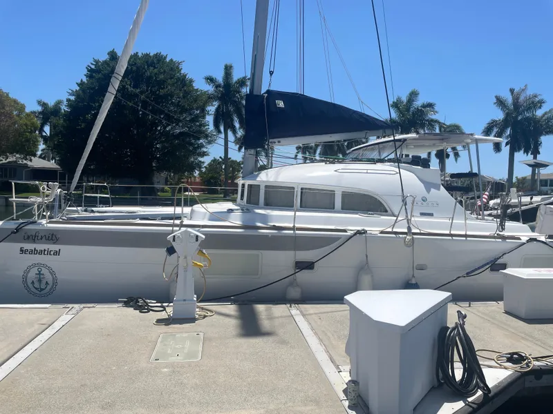 Slide: The Image of 2016 Lagoon 380 catamaran docked under clear blue sky with palm trees. - 5