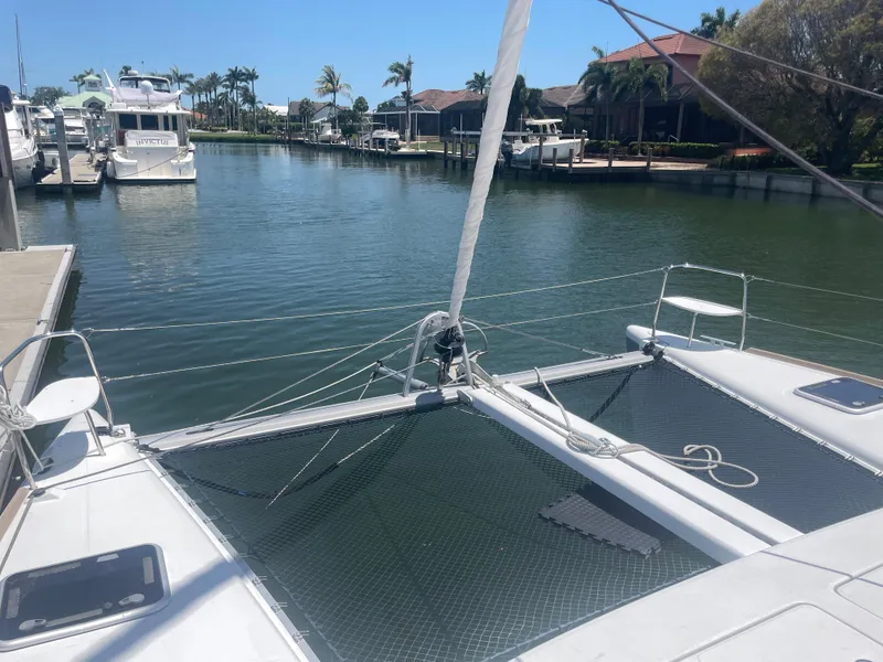 Slide: The Image of 2016 Lagoon 380 catamaran docked in a serene marina with palm trees. - 9