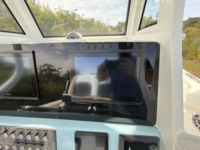 Slide: The Image of 2024 Tidewater 256 CC Adventure boat dashboard with Garmin displays and control panel. - 19
