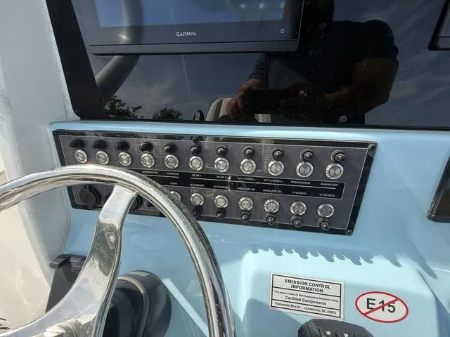 Slide: The Image of 2024 Tidewater 256 CC Adventure boat dashboard with steering wheel and control panel. - 21