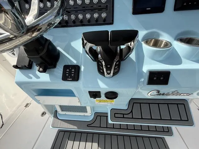 Slide: The Image of 2024 Tidewater 256 CC Adventure boat console with controls and cup holders. - 22
