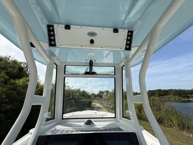 Slide: The Image of 2024 Tidewater 256 CC Adventure boat interior with blue canopy and scenic waterway view. - 23