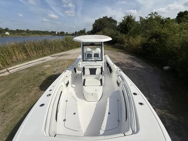 Slide: The Image of 2024 Tidewater 256 CC Adventure boat on a scenic riverside path. - 28