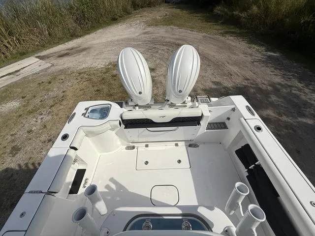 Slide: The Image of 2024 Tidewater 256 CC Adventure boat with dual engines, viewed from above, on a dirt path. - 33