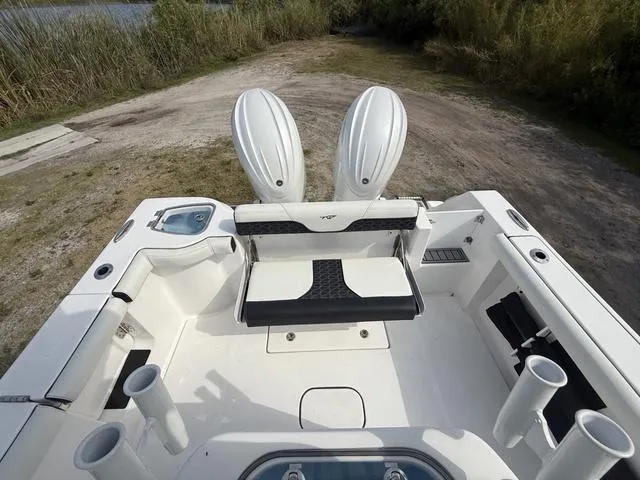 Slide: The Image of 2024 Tidewater 256 CC Adventure boat interior with dual engines and fishing rod holders. - 34