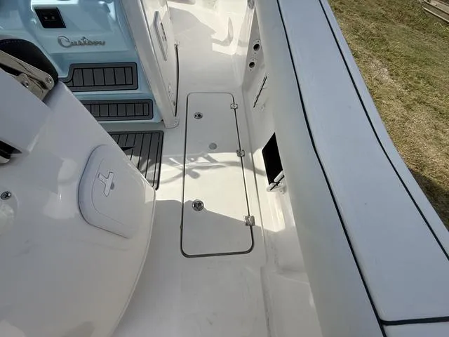 Slide: The Image of 2024 Tidewater 256 CC Adventure boat deck with storage compartments and seating area. - 45