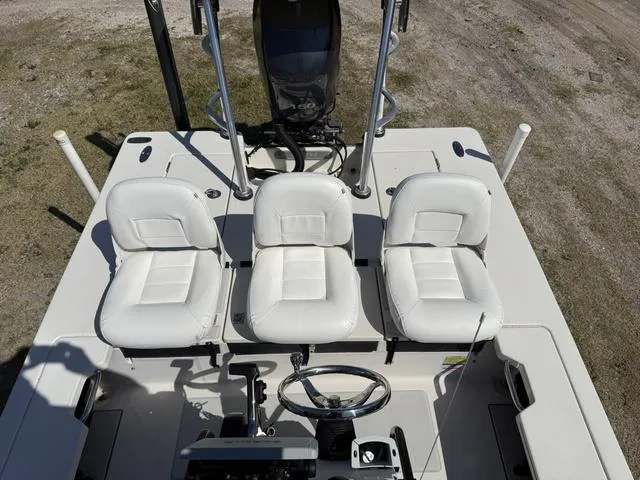 Slide: The Image of 2009 Hewes 18 Redfisher boat interior with three white seats and steering wheel. - 18