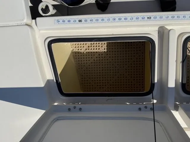 Slide: The Image of Open hatch on 2009 Hewes 18 Redfisher boat, showing interior storage space. - 27