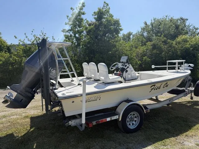 Slide: The Image of 2009 Hewes 18 Redfisher boat on trailer, parked outdoors near trees. - 6