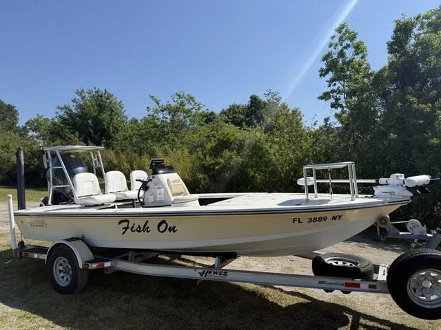 Slide: The Image of 2009 Hewes 18 Redfisher boat on trailer, labeled "Fish On," parked outdoors. - 8