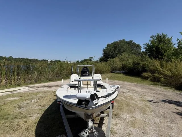 Slide: The Image of 2009 Hewes 18 Redfisher boat on trailer near a lake, surrounded by greenery. - 9