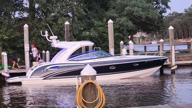 Slide: The Image of 2020 Formula 350 Sun Sport boat docked by a scenic waterfront. - 0