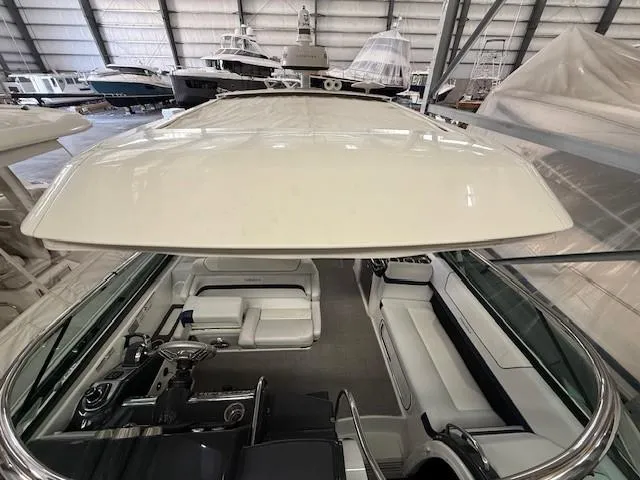 Slide: The Image of 2020 Formula 350 Sun Sport boat interior in a storage facility, showcasing seating and helm. - 23