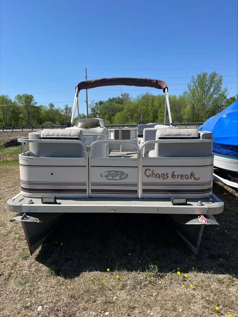 Slide: The Image of 2003 Manitou Osprey pontoon boat on land, rear view, with "Chaos Break" text. - 10