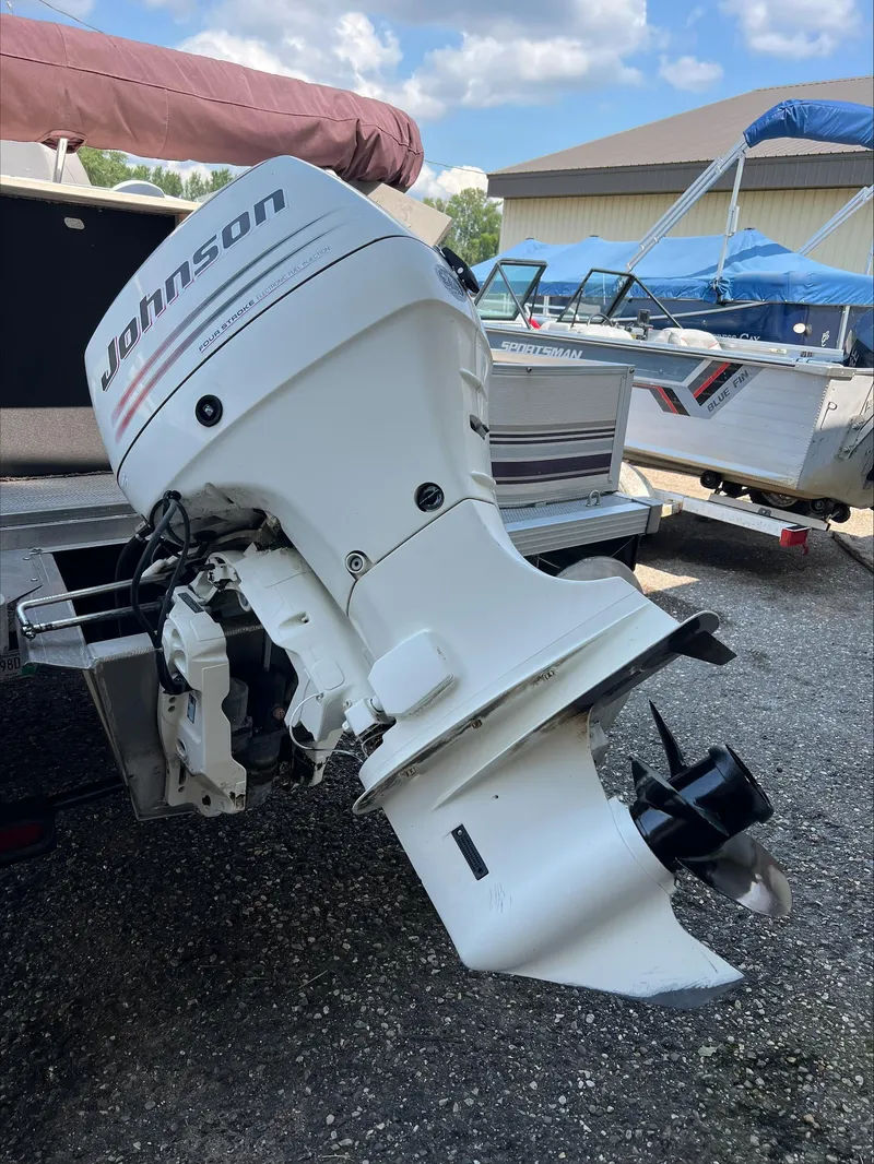 Slide: The Image of Outboard motor on a 2003 Manitou Osprey boat, featuring a Johnson engine. - 2