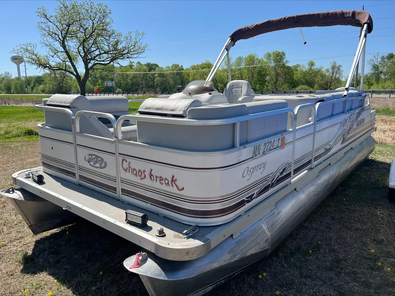 Slide: The Image of 2003 Manitou Osprey pontoon boat parked on grass, featuring "Chaos Break" text on the side. - 4