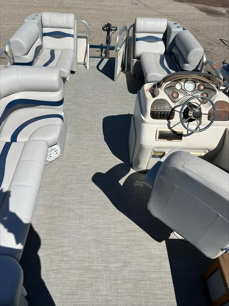 Slide: The Image of 2003 Manitou Osprey pontoon boat interior with spacious seating and modern dashboard. - 7