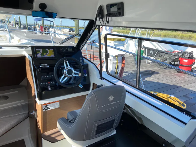 Slide: The Image of Interior of 2021 Jeanneau NC795 S2 boat with steering wheel and navigation system. - 10