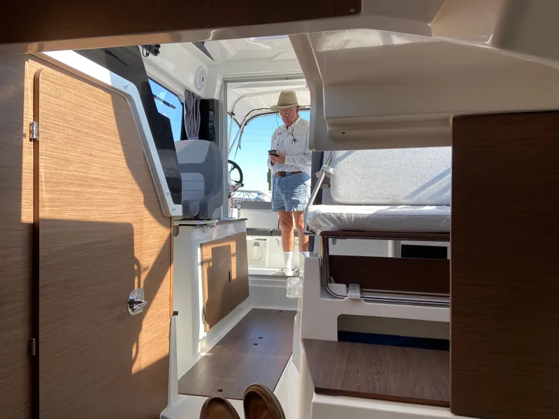 Slide: The Image of Interior of 2021 Jeanneau NC795 S2 boat with person standing near helm. - 12