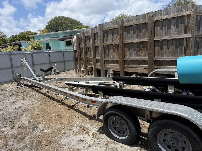 Slide: The Image of Boat trailer for Jeanneau NC795 S2, 2021 model, parked outdoors near wooden fence. - 13