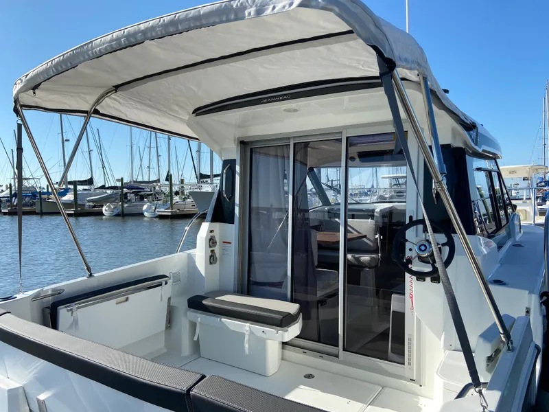 Slide: The Image of 2021 Jeanneau NC795 S2 boat with canopy, docked at marina. - 7