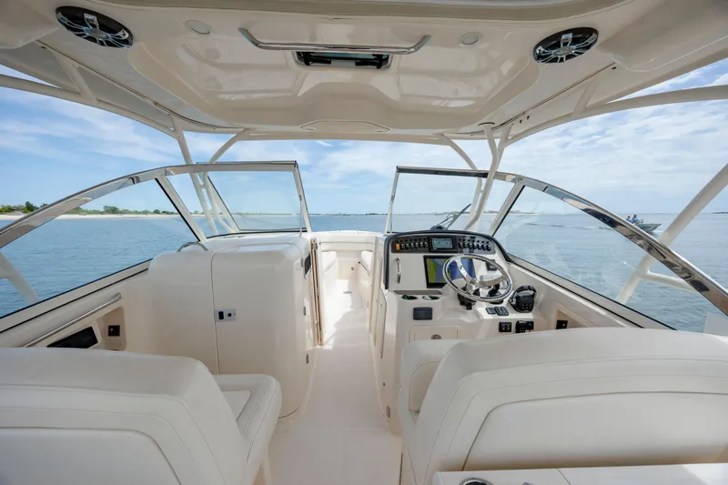 Slide: The Image of 2020 Grady-White Freedom 307 boat interior with helm, ocean view, and clear skies. - 13
